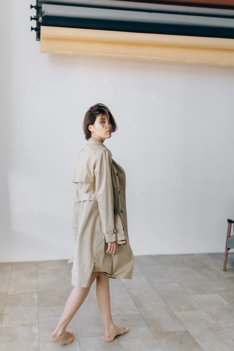 The Coat — a long belted trench in warm sand